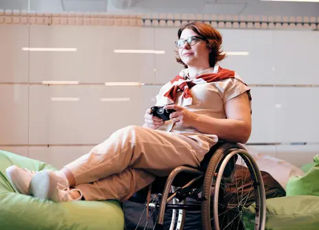 Woman Sitting on Black Wheelchair While Holding Game Controller