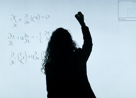 A shadow writes on board