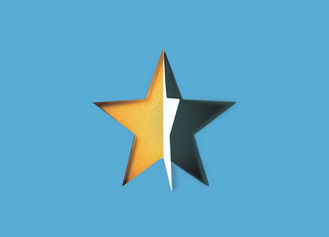 A five pointed star is half gold and half black. The black layer has been peeled away from the gold one.
