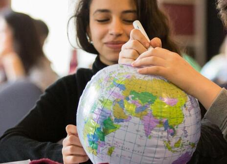 a student is looking at a globe