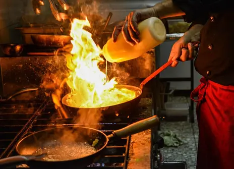 Picture of flame in a pan cooking on a hob.