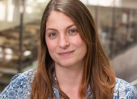 woman with long brown hair and a blue white patterned top