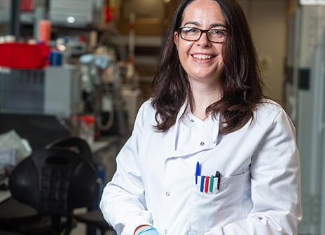 Teresa Lambe in a white lab coat and blue nitrile gloves in a lab