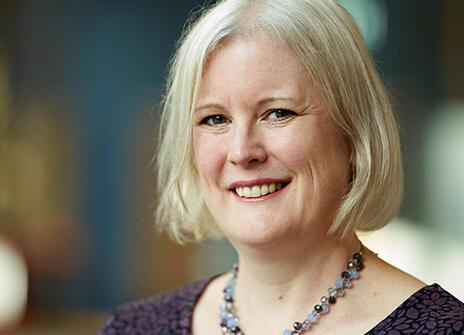 Catherine Noakes with a short blond bob haircut and a chunky necklace smiling